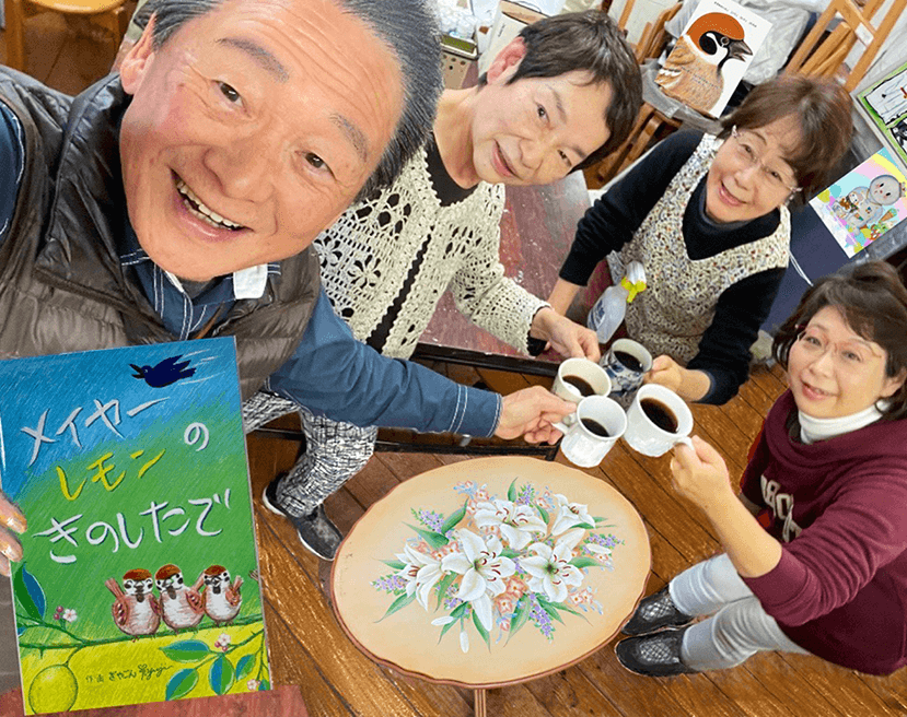 完成した絵本と一緒に写る、沼上さんと「kikori」の生徒さんたち