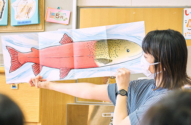 『イトウってなーんだ？』の絵本を読み聞かせる様子